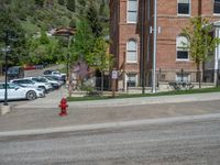 a big house with two fire trucks parked next to it and mountains in the background