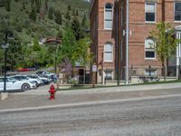 a big house with two fire trucks parked next to it and mountains in the background