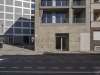 the wall of an apartment building that has writing on it's side of it