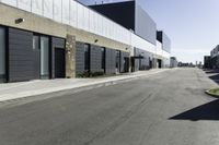 a car driving past the empty commercial building on an empty street in front of a sidewalk