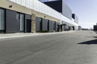 a car driving past the empty commercial building on an empty street in front of a sidewalk