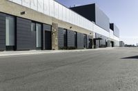 a car driving past the empty commercial building on an empty street in front of a sidewalk