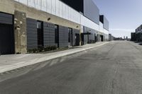 a car driving past the empty commercial building on an empty street in front of a sidewalk