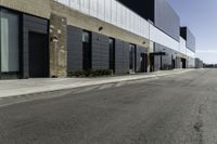 a car driving past the empty commercial building on an empty street in front of a sidewalk