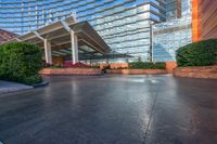 large building with stone floors in large courtyard area by stone columns, plants and a walkway