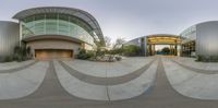 a wide angle of the facade of a building with a circular driveway with an outdoor fountain in front