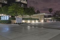 a view of an office building at night from a parking lot looking outside at it