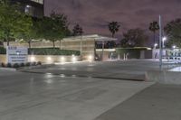 a view of an office building at night from a parking lot looking outside at it