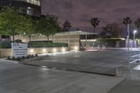 a view of an office building at night from a parking lot looking outside at it