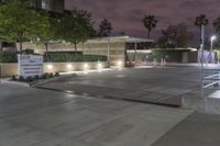 a view of an office building at night from a parking lot looking outside at it