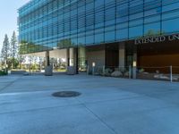 two grey blocks sitting next to a tall building on a sidewalk in front of grass