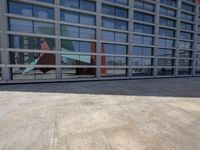 a building with large glass windows is pictured here looking forward on the ground next to the building