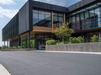 a building with a logo painted on the side near a street that has a sidewalk next to it