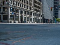 the green paint is painted on a bike path in front of an office building and large, trees