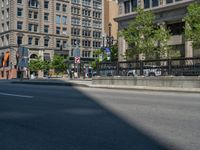 an empty street with buildings and parked cars on the sidewalks and green lanes on the sidewalk