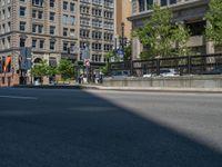 an empty street with buildings and parked cars on the sidewalks and green lanes on the sidewalk