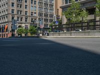 an empty street with buildings and parked cars on the sidewalks and green lanes on the sidewalk