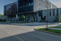 the empty sidewalk in front of a modern building with an elevator in it's corner