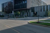 the empty sidewalk in front of a modern building with an elevator in it's corner