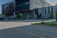 the empty sidewalk in front of a modern building with an elevator in it's corner