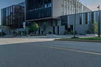 the empty sidewalk in front of a modern building with an elevator in it's corner