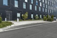 a black building on the corner with a painted line across the side and trees by the side