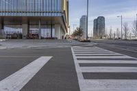 the building has a big number of windows in it that makes a nice contrast to the crosswalk