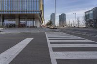 the building has a big number of windows in it that makes a nice contrast to the crosswalk