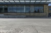 an empty building on a city street corner with yellow line and parking meter outside of the entrance