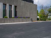 a building with a logo painted on the side near a street that has a sidewalk next to it