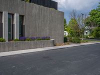 a building with a logo painted on the side near a street that has a sidewalk next to it