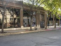 a store that is in a big city street with no cars on it, next to a fire hydrant