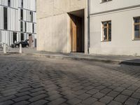 a person with a suitcase walking across an outside courtyard in front of a building,