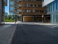 a road through which is a large modern building with an awning over it's entrance