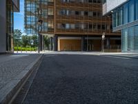 a road through which is a large modern building with an awning over it's entrance