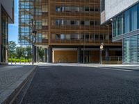 a road through which is a large modern building with an awning over it's entrance