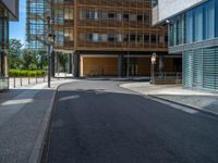 a road through which is a large modern building with an awning over it's entrance