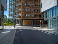 a road through which is a large modern building with an awning over it's entrance