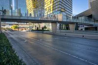 two highrise buildings are in the foreground and a pedestrian bridge overpass between them