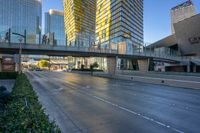 two highrise buildings are in the foreground and a pedestrian bridge overpass between them