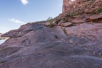a trail is winding down a mountain, which is surrounded by rock formations and large boulders
