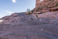a trail is winding down a mountain, which is surrounded by rock formations and large boulders
