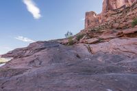 a trail is winding down a mountain, which is surrounded by rock formations and large boulders