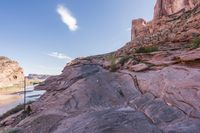 a trail is winding down a mountain, which is surrounded by rock formations and large boulders