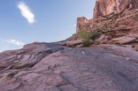 a trail is winding down a mountain, which is surrounded by rock formations and large boulders