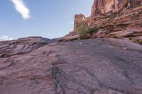 a trail is winding down a mountain, which is surrounded by rock formations and large boulders