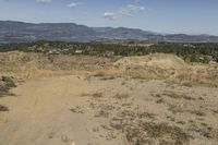 there is a bike rider on a paved dirt road through rocky area near a mountain