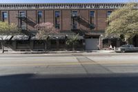 an old brick building with a car parked on the street in front of it is a commercial area next to the large warehouse