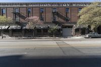 an old brick building with a car parked on the street in front of it is a commercial area next to the large warehouse