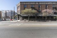 an old brick building with a car parked on the street in front of it is a commercial area next to the large warehouse